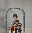 Child sitting on a luggage trolley, being pushed along in a playful, travel‑ready setting.