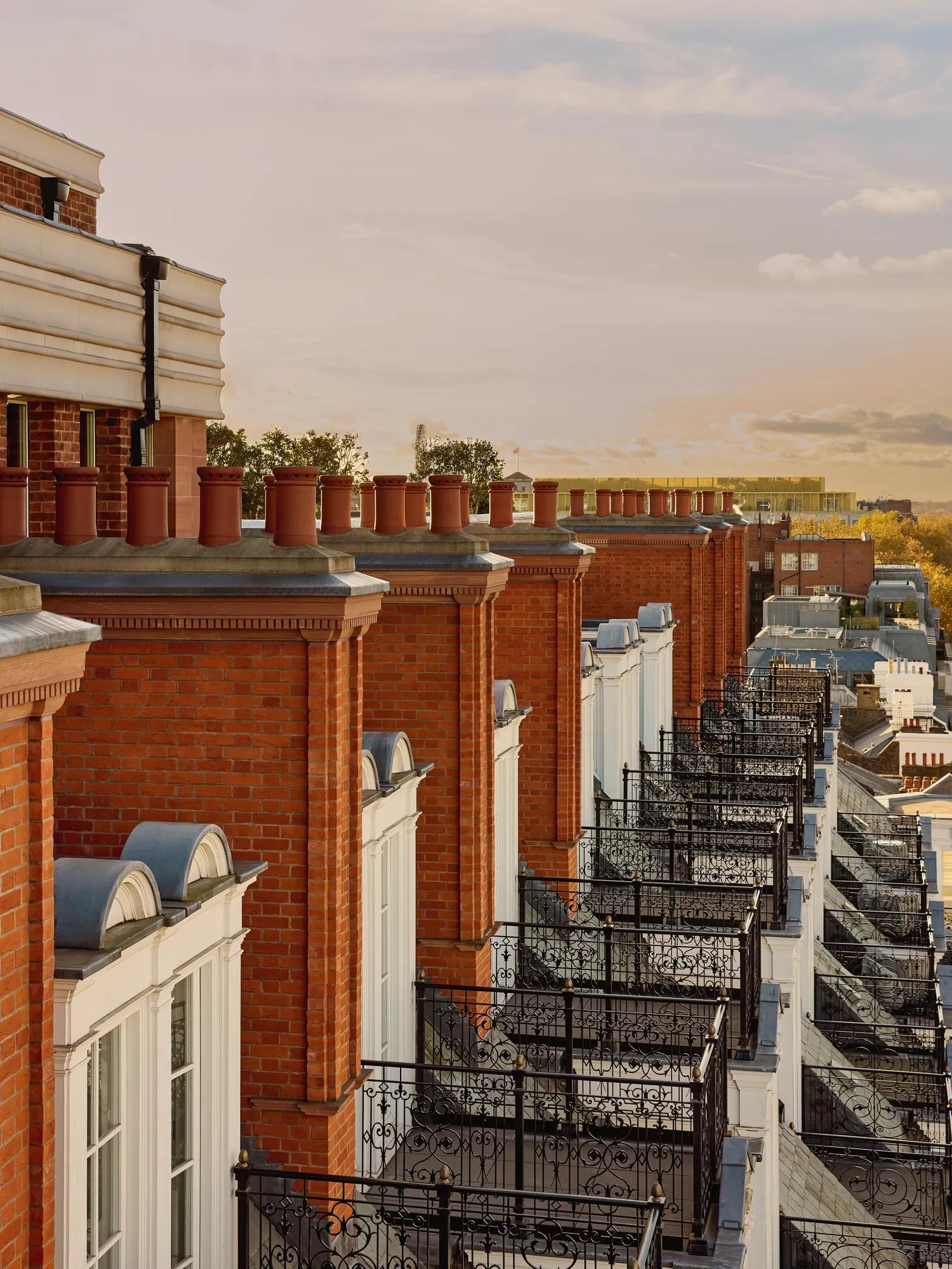 Row of red-brick façades with ornate black balconies at Claridge’s, overlooking Mayfair at sunset