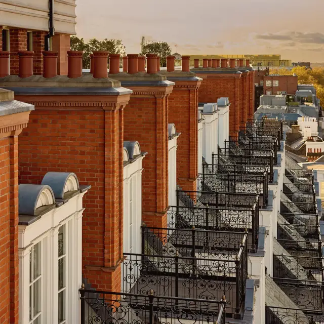 Row of red-brick façades with ornate black balconies at Claridge’s, overlooking Mayfair at sunset