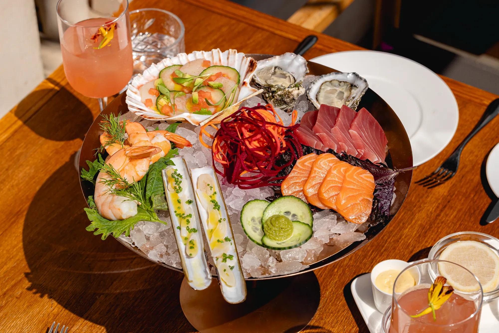 	Plate of sashimi featuring sliced raw fish arranged in rows with garnish on the side.