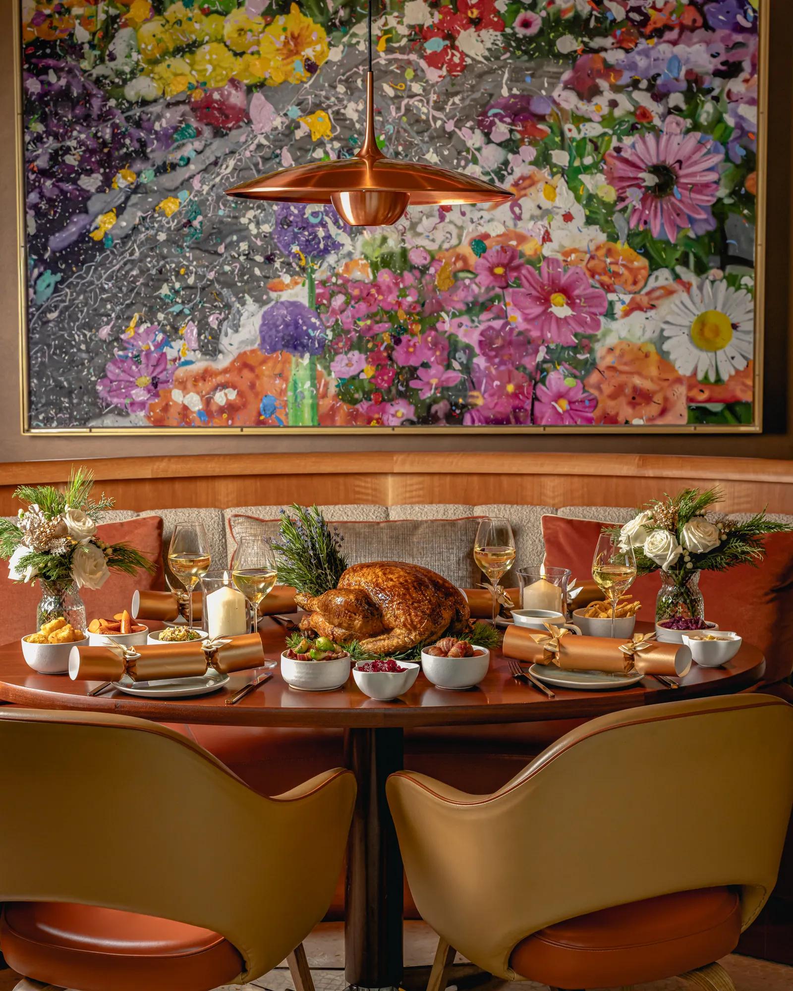 A festive table setting with a whole turkey, sides and decorations