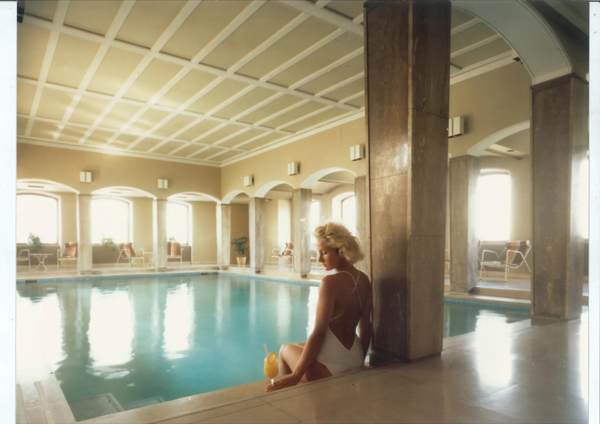 An image of a woman sitting beside a pool