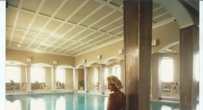 An image of a woman sitting beside a pool