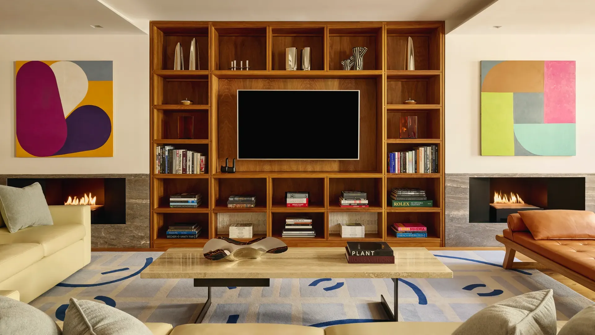 Contemporary living room with wood shelving, modern art, twin fireplaces, and cream sofas.