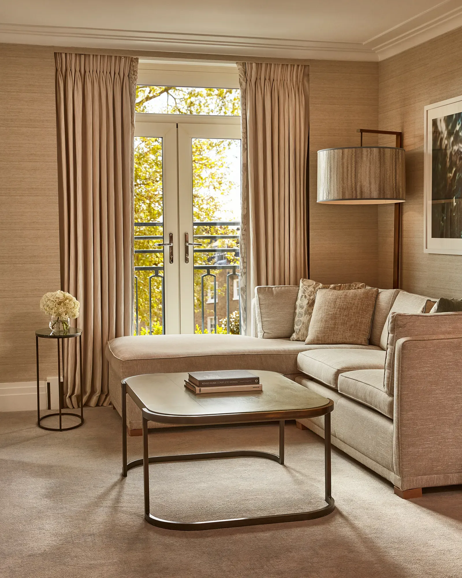 Elegant lounge with corner sofa, coffee table, and French doors opening to a Juliet balcony.