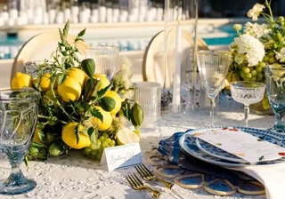 Rooftop poolside dining setup in Beverly Hills with citrus centerpieces and blue patterned plates.