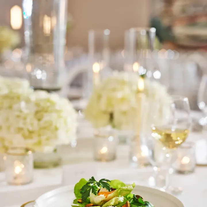 Butter-lettuce salad with apricots, goat cheese, and pistachios on fine china.