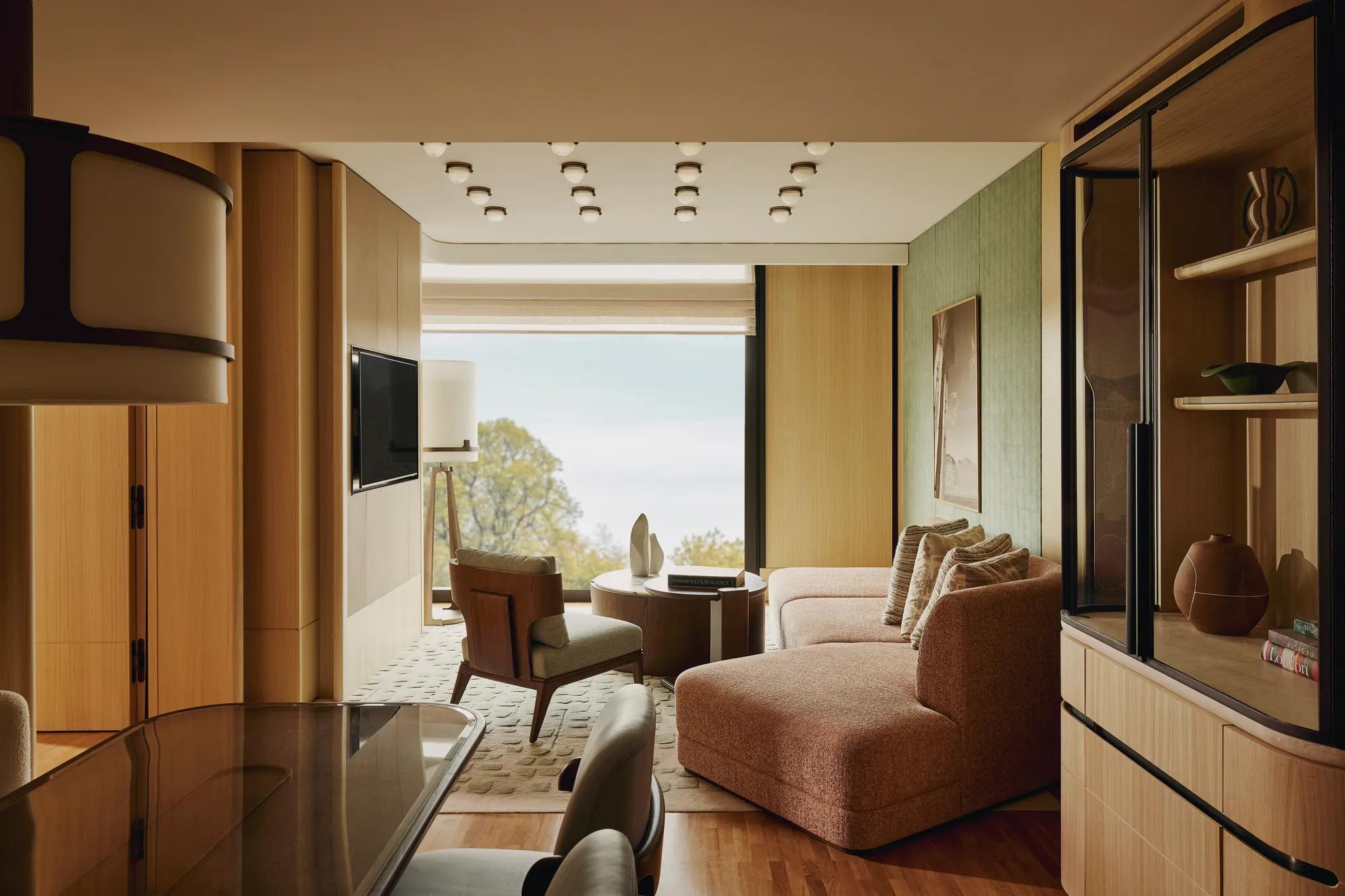 A modern red sofa with smooth upholstery, straight armrests, and wooden legs, positioned against a neutral background.