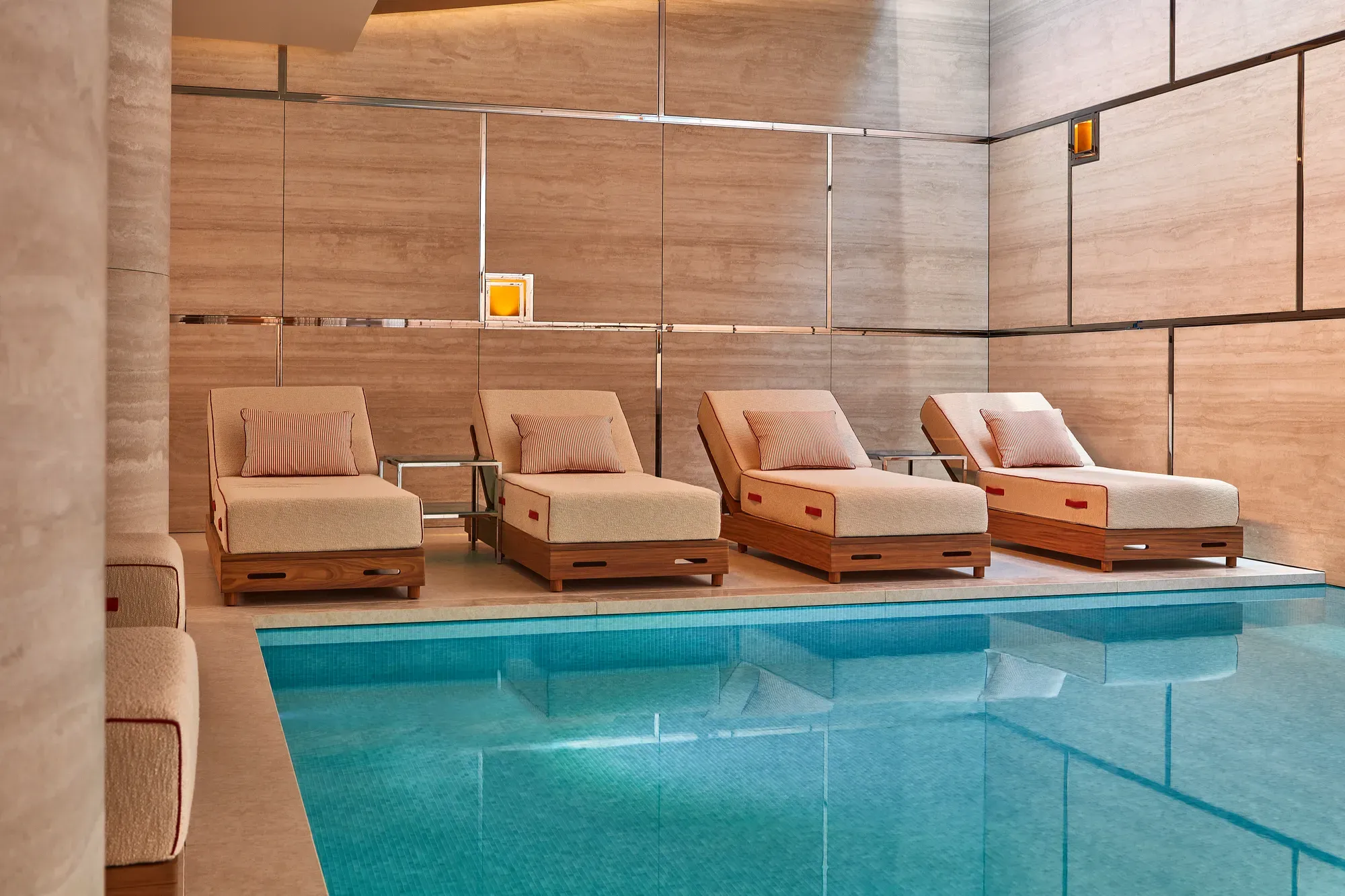 A serene spa setting featuring soft ambient lighting, neatly rolled towels, and natural elements like candles and smooth stones arranged on a wooden surface, creating a calm and relaxing atmosphere.