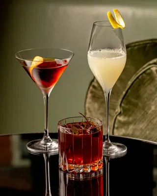 A photo of three cocktails on a table
