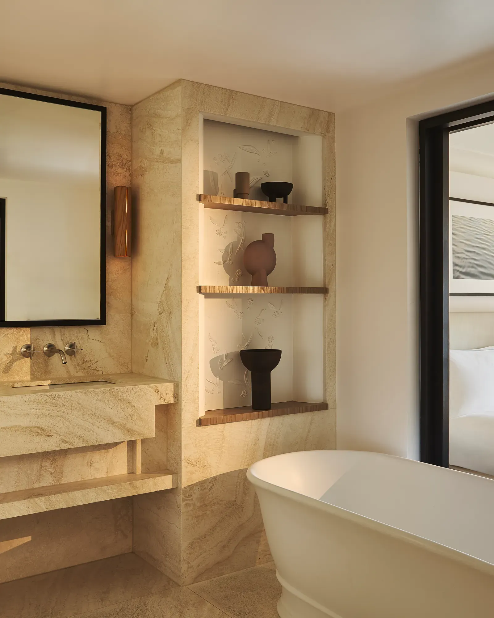 Elegant bathroom featuring white marble floors and walls, a soaking tub and chrome fixtures