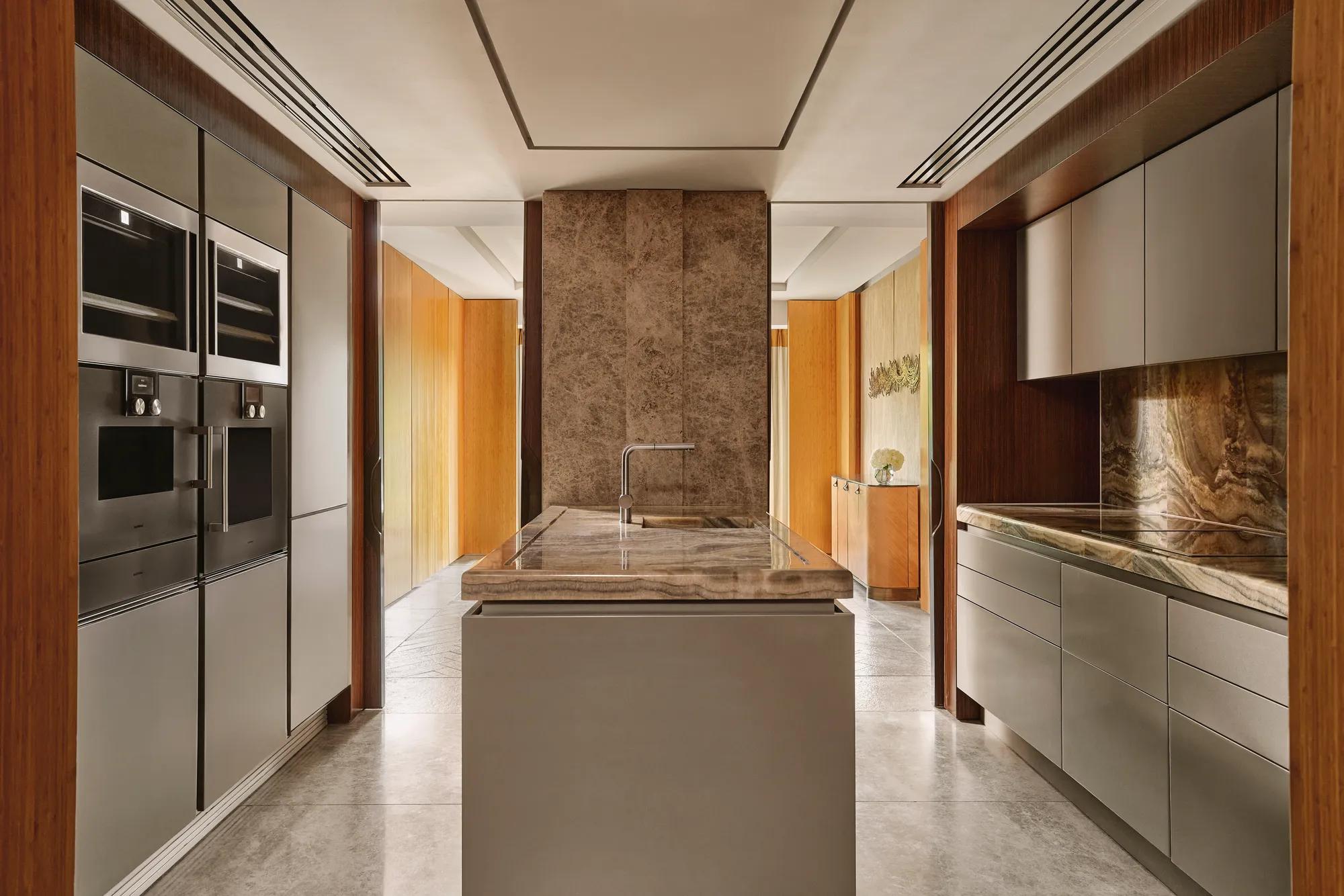 Modern kitchen with marble island, integrated appliances, and sleek cabinetry in the Opus Suite.
