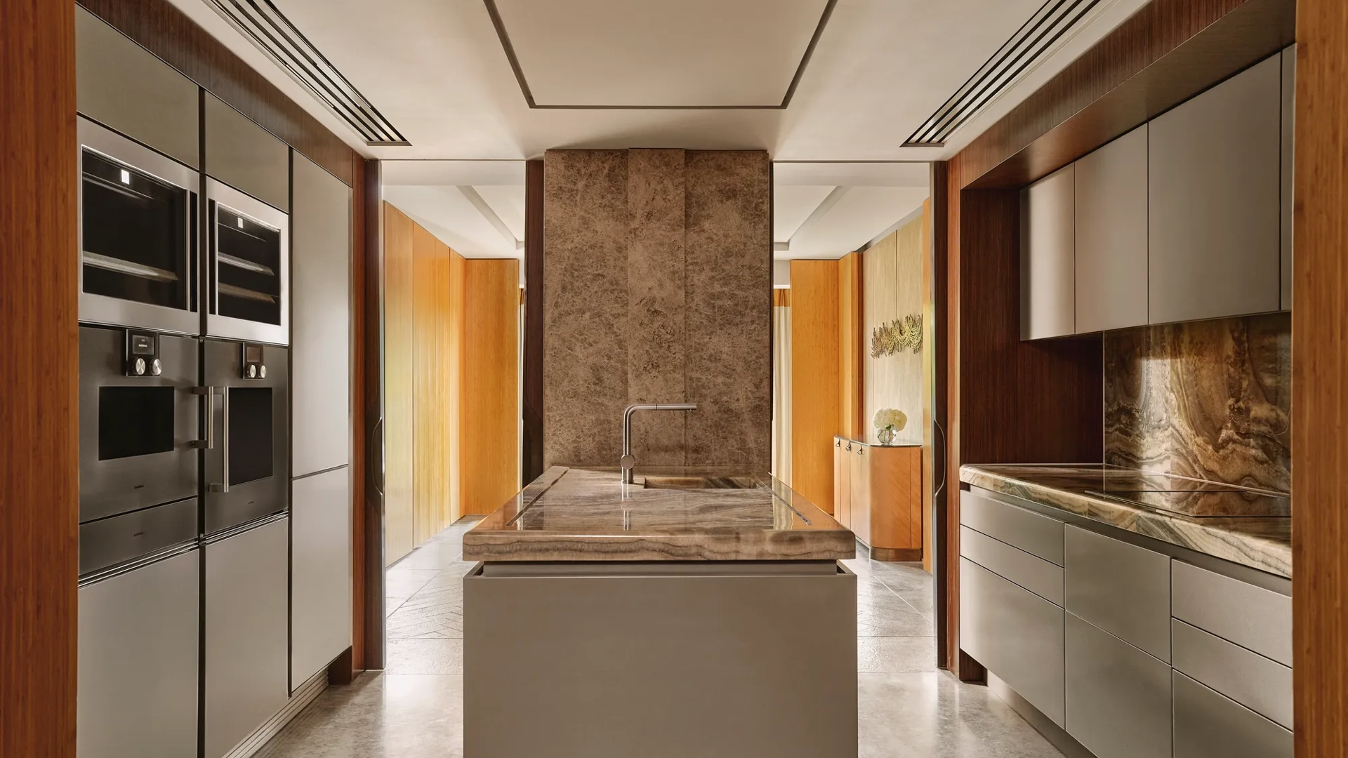 Modern kitchen with marble island, integrated appliances, and sleek cabinetry in the Opus Suite.