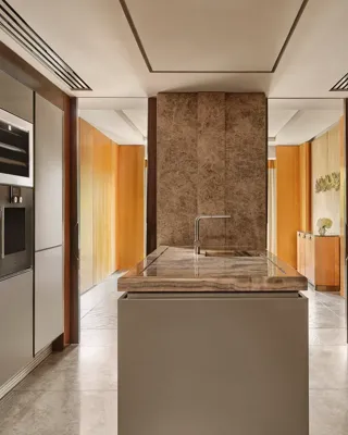 Modern kitchen with marble island, integrated appliances, and sleek cabinetry in the Opus Suite.