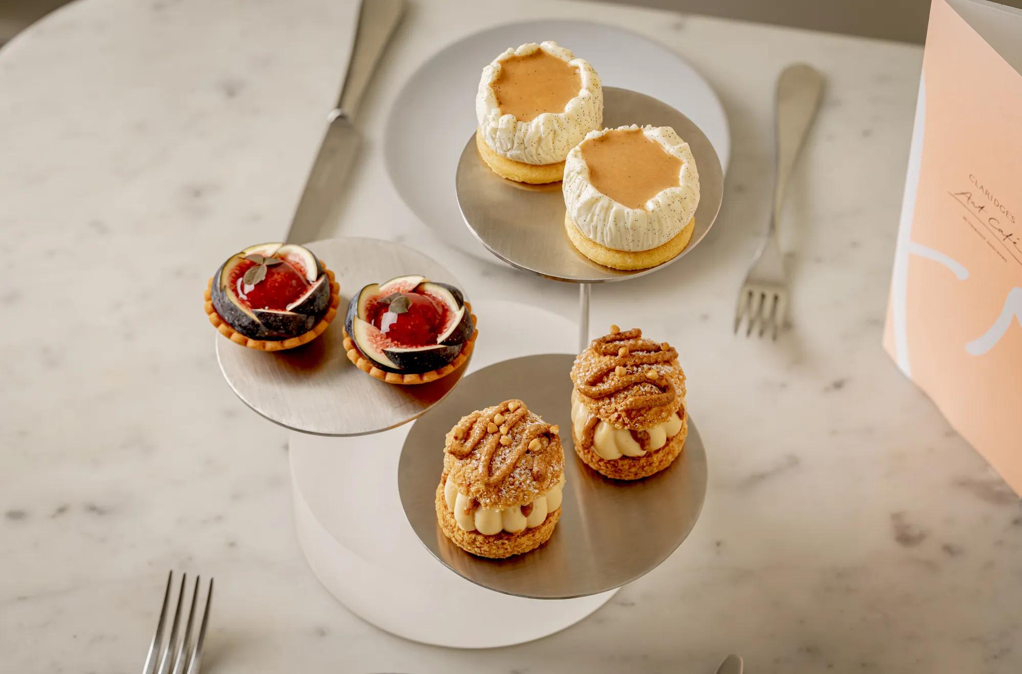An assortment of pastries displayed on a tiered stand on a marble table.