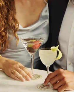 Couple holding martini and cocktail at a marble table at Dante rooftop restaurant