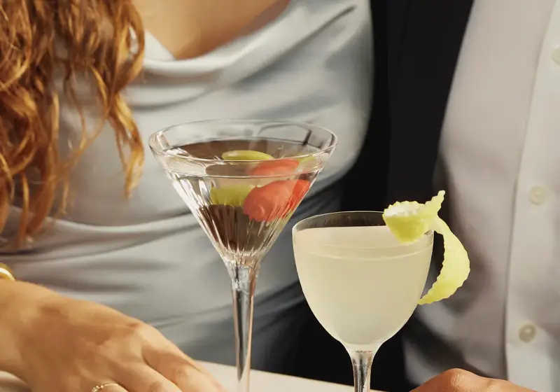 Couple holding martini and cocktail at a marble table at Dante rooftop restaurant