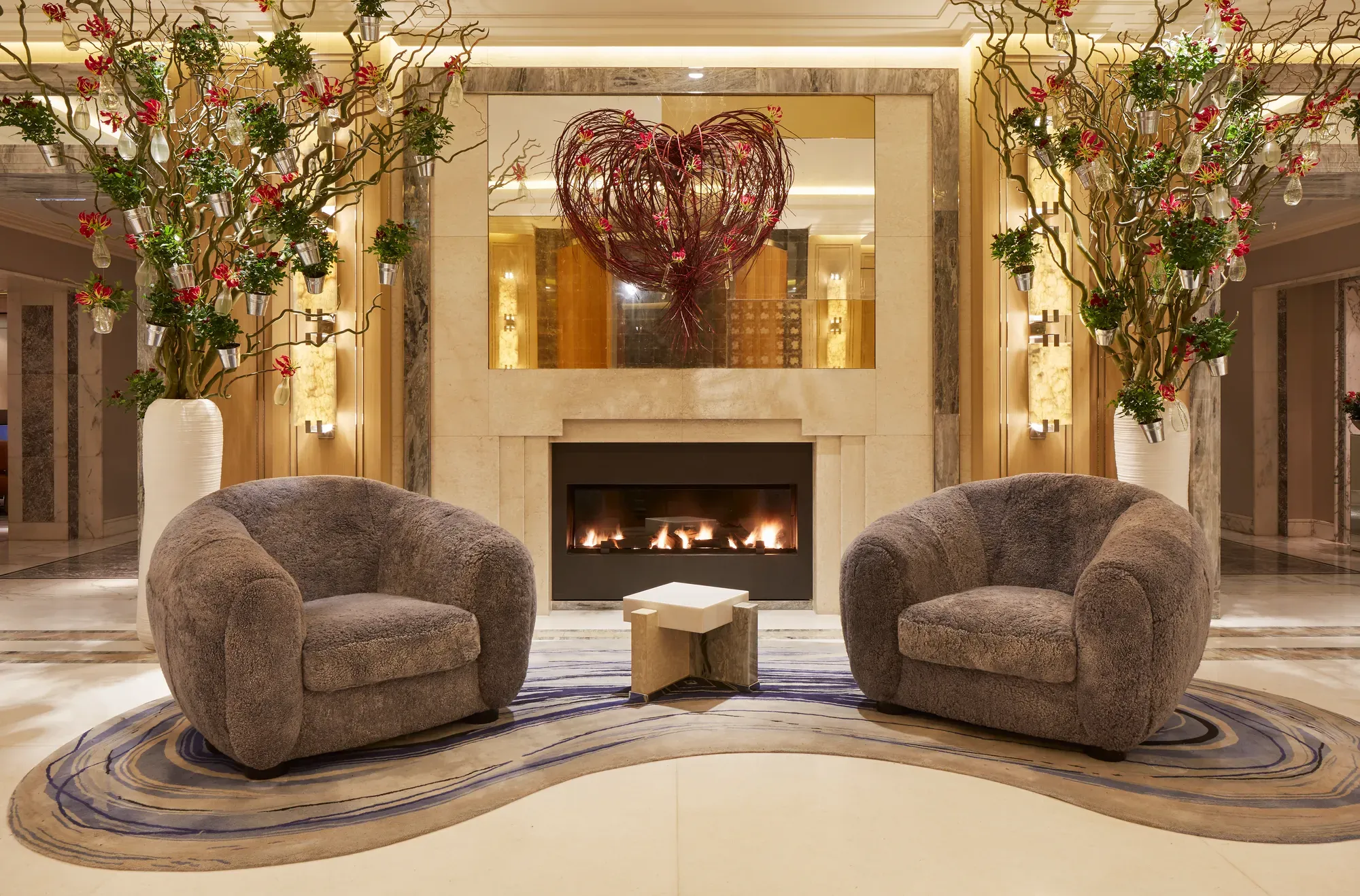 Two comfortable sofas arranged around a glowing fireplace, creating a cozy and inviting atmosphere.