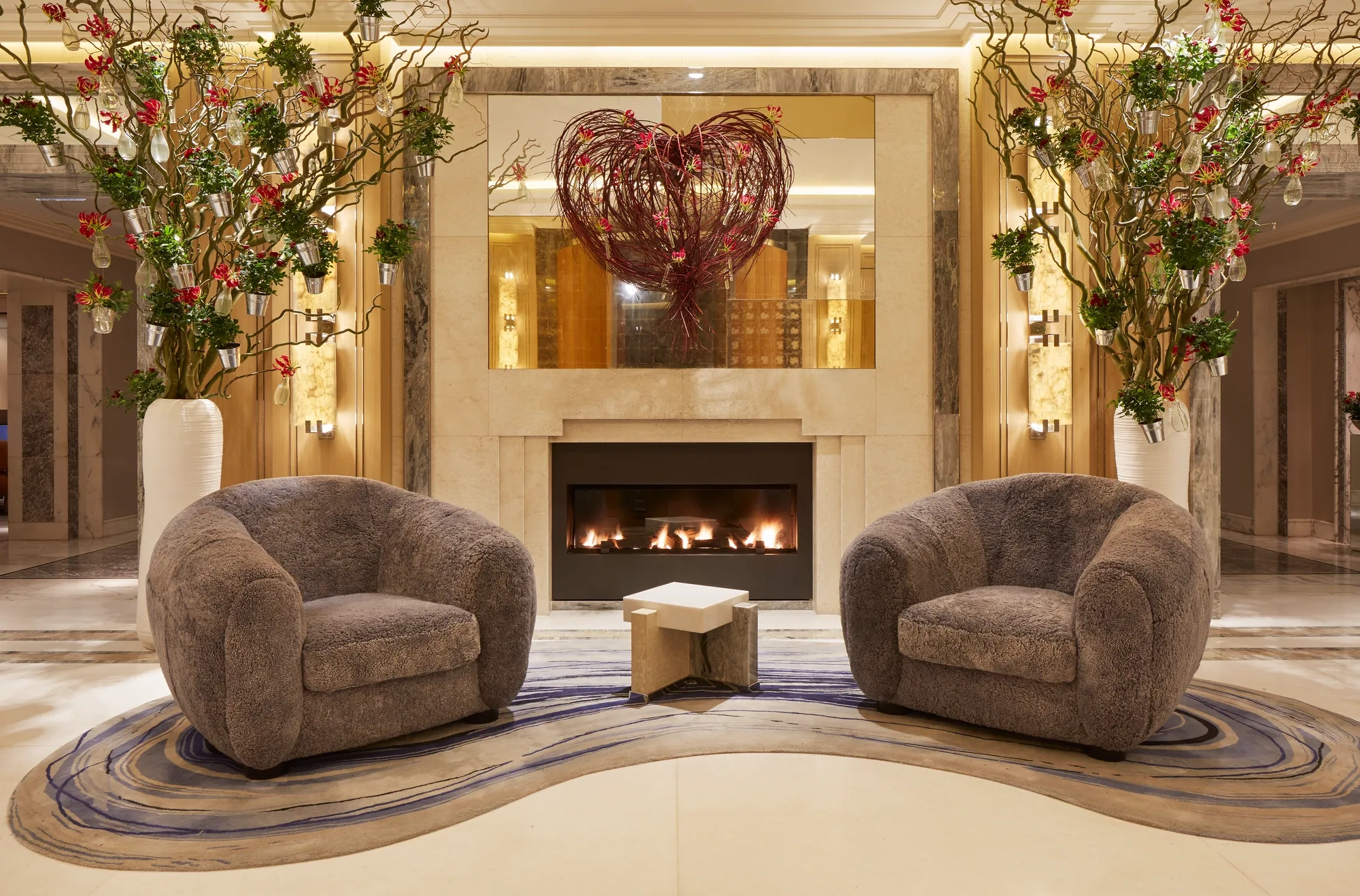 Two comfortable sofas arranged around a glowing fireplace, creating a cozy and inviting atmosphere.