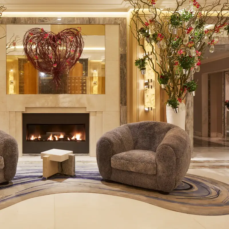 Two comfortable sofas arranged around a glowing fireplace, creating a cozy and inviting atmosphere.