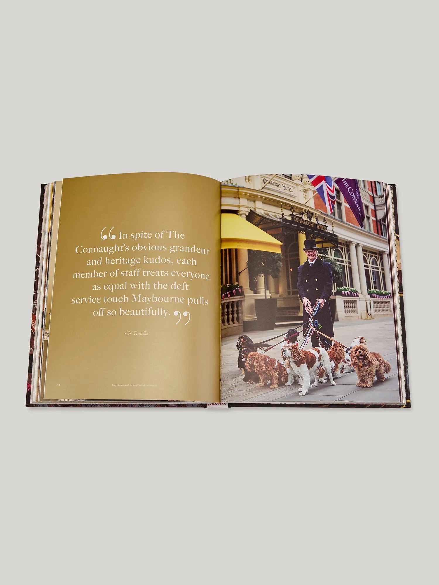 Open book spread with a quote page beside a photograph of a uniformed doorman walking dogs outside The Connaught entrance.