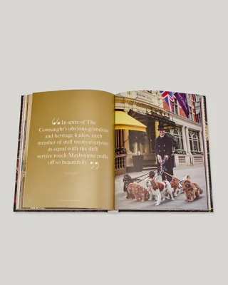 Open book spread with a quote page beside a photograph of a uniformed doorman walking dogs outside The Connaught entrance.