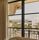 White sofa positioned in front of large windows with a sweeping view over the hills of Beverly Hills