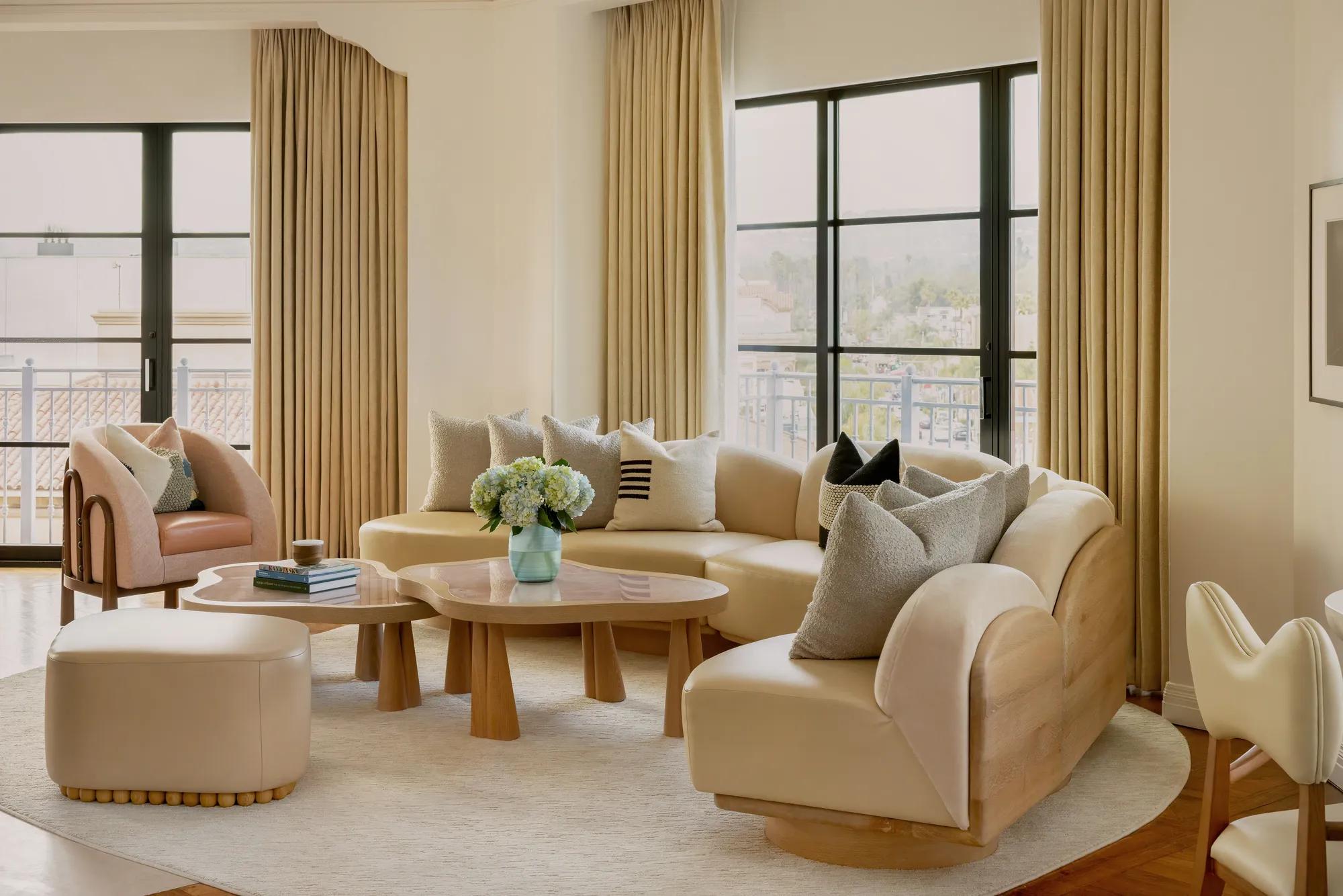 Hollywood Suite lounge corner with curved sofa and panoramic Beverly Hills outlook.