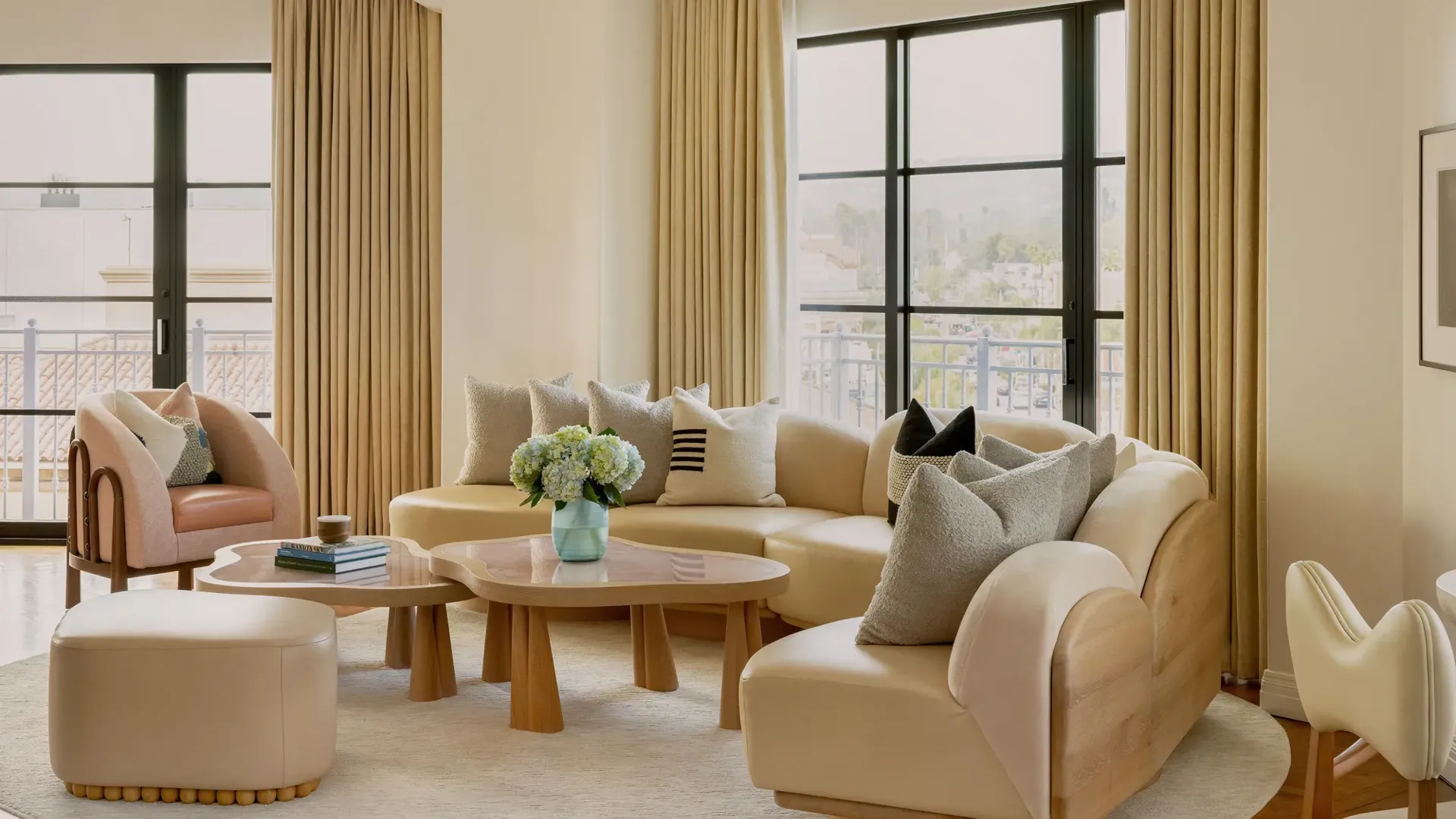 Hollywood Suite lounge corner with curved sofa and panoramic Beverly Hills outlook.