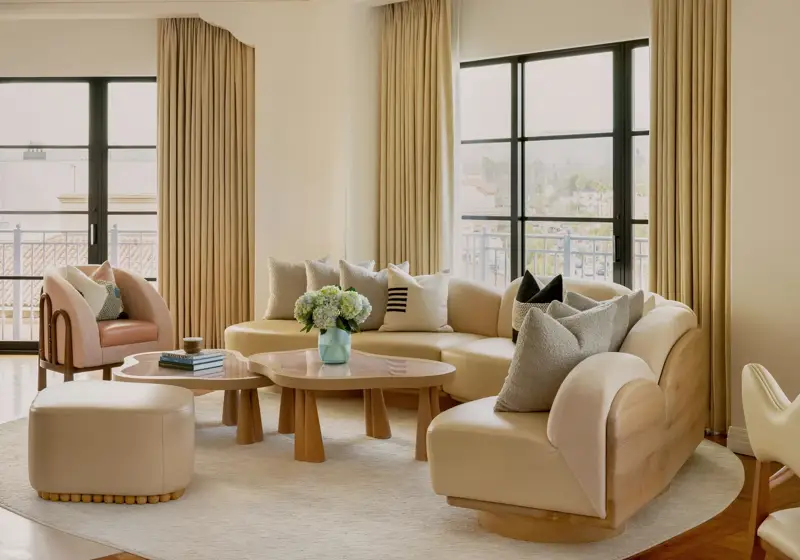 Hollywood Suite lounge corner with curved sofa and panoramic Beverly Hills outlook.