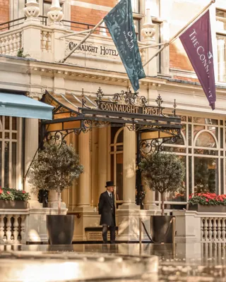 Entrance of The Connaught hotel with its signature canopy and flags above the doorway.