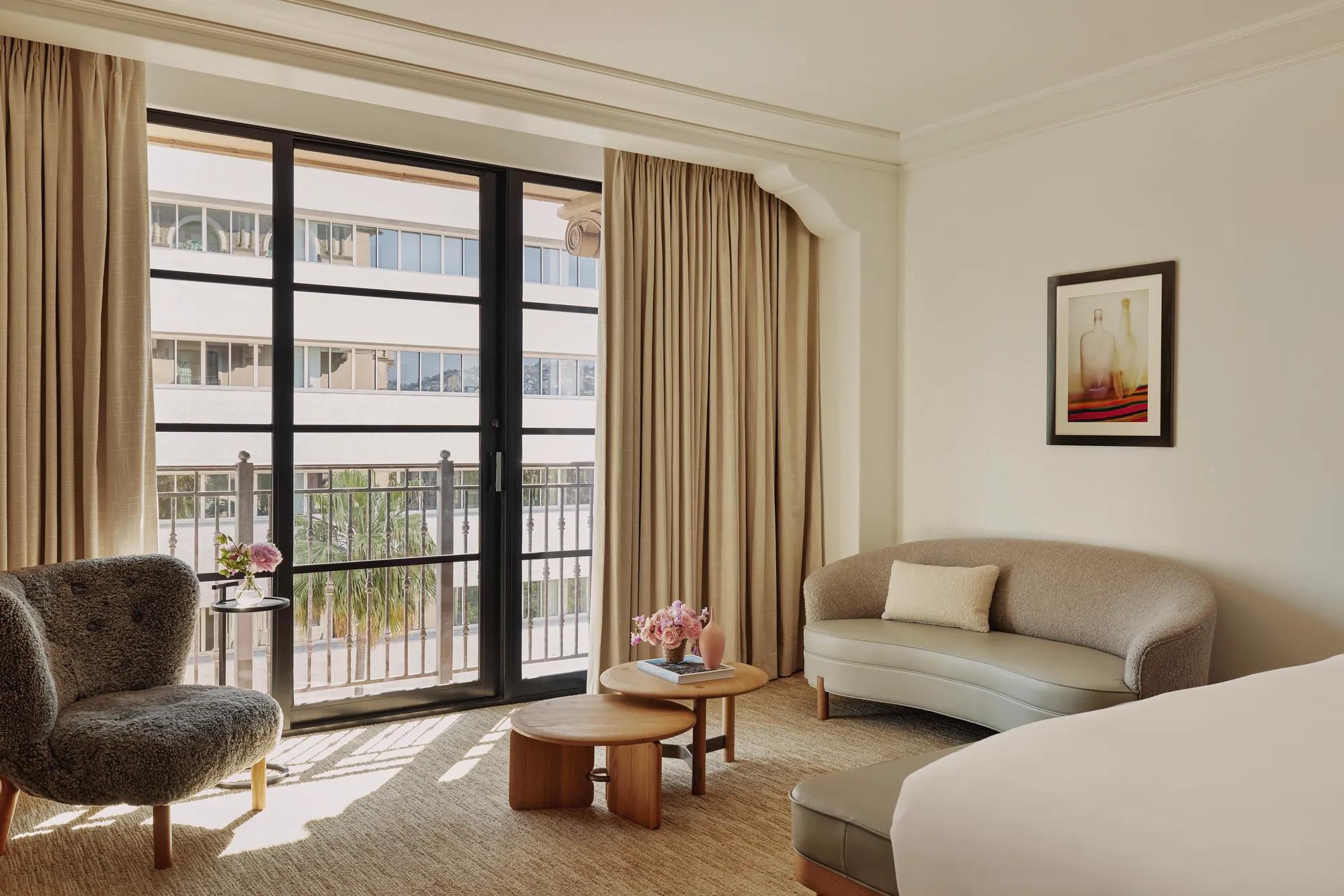 Seating area in Deluxe Room with sofa, coffee table, and large window.