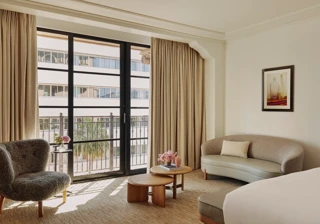 Seating area in Deluxe Room with sofa, coffee table, and large window.