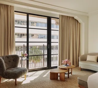 Seating area in Deluxe Room with sofa, coffee table, and large window.