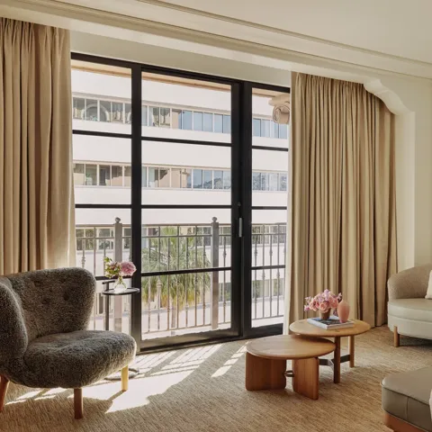 Seating area in Deluxe Room with sofa, coffee table, and large window.