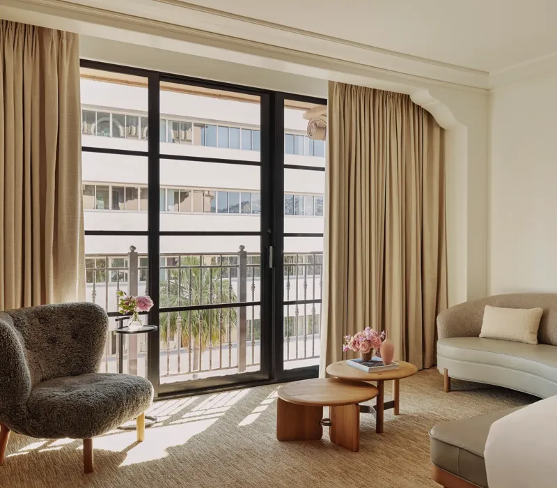 Seating area in Deluxe Room with sofa, coffee table, and large window.