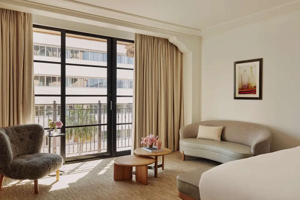 Seating area in Deluxe Room with sofa, coffee table, and large window.