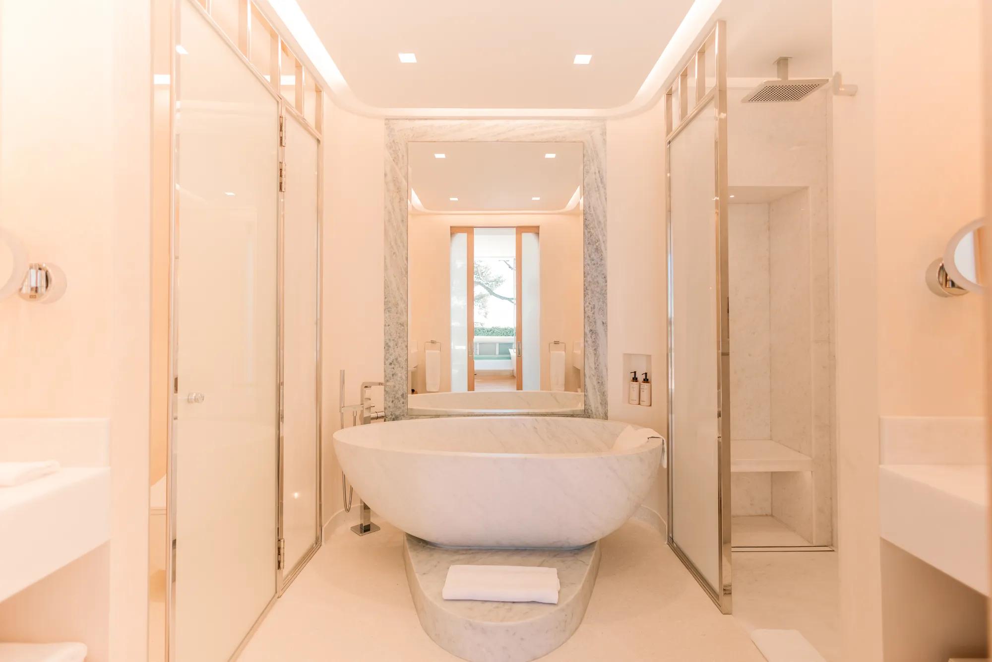 Elegant marble bathroom with freestanding bathtub, walk-in shower and double vanity.
