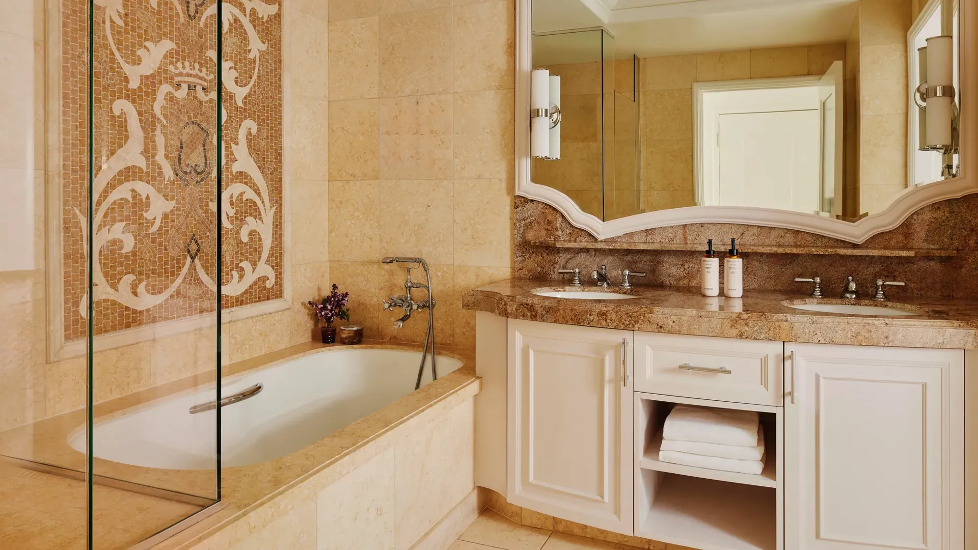 Marble bathroom with double vanity, large mirror, tub and walk-in shower.