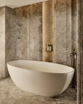 Marble bathroom with freestanding oval bathtub and warm accent lighting