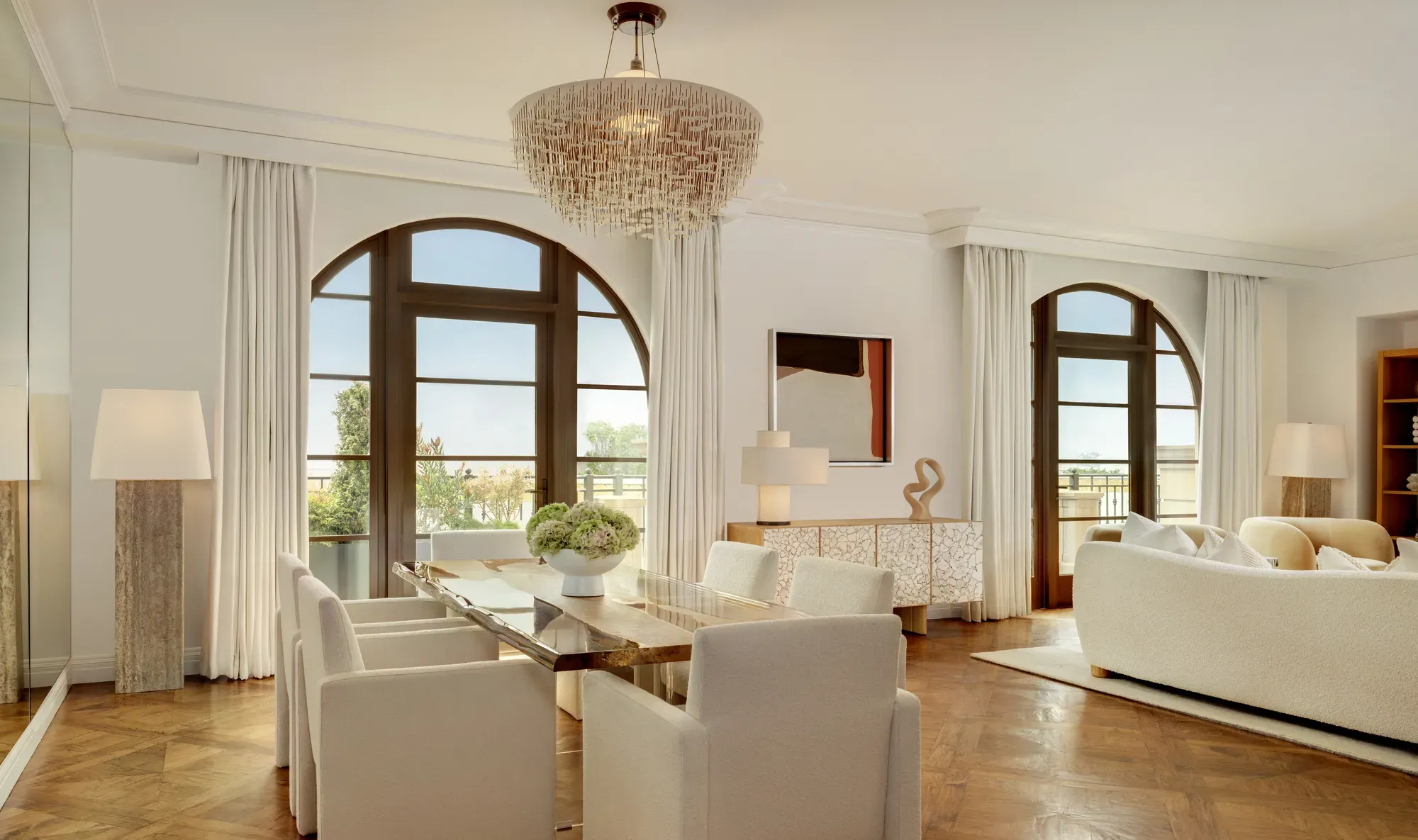 Bright living area in The Maybourne Three-Bed Residence Wilshire with a plush sofa, coffee table, and access to a private balcony.