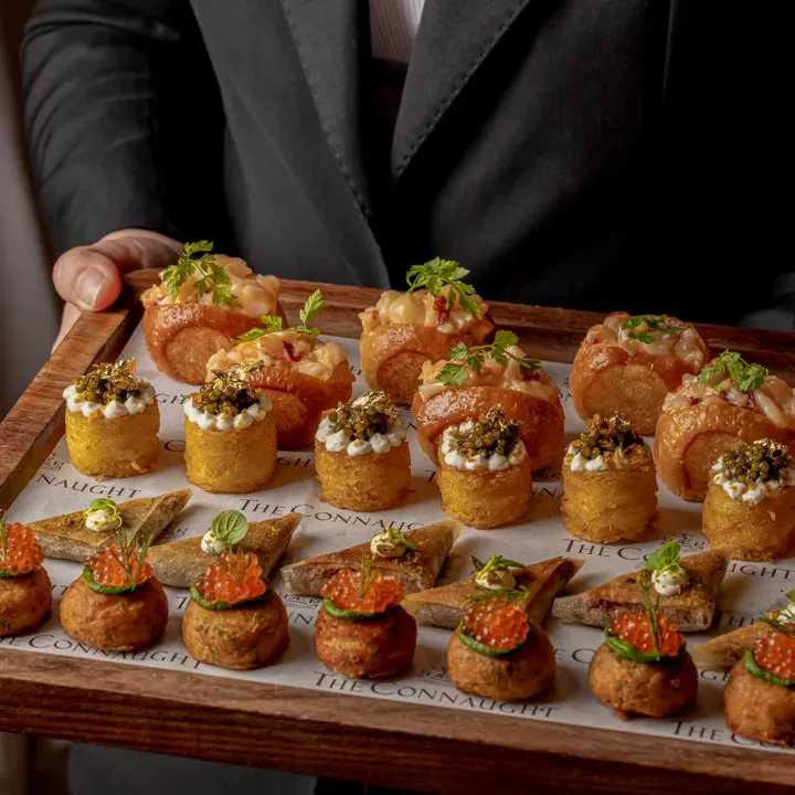 An elegant selection of canapés served for a private event at Claridge’s, presented with refined plating and arranged on a stylish display for a sophisticated reception.