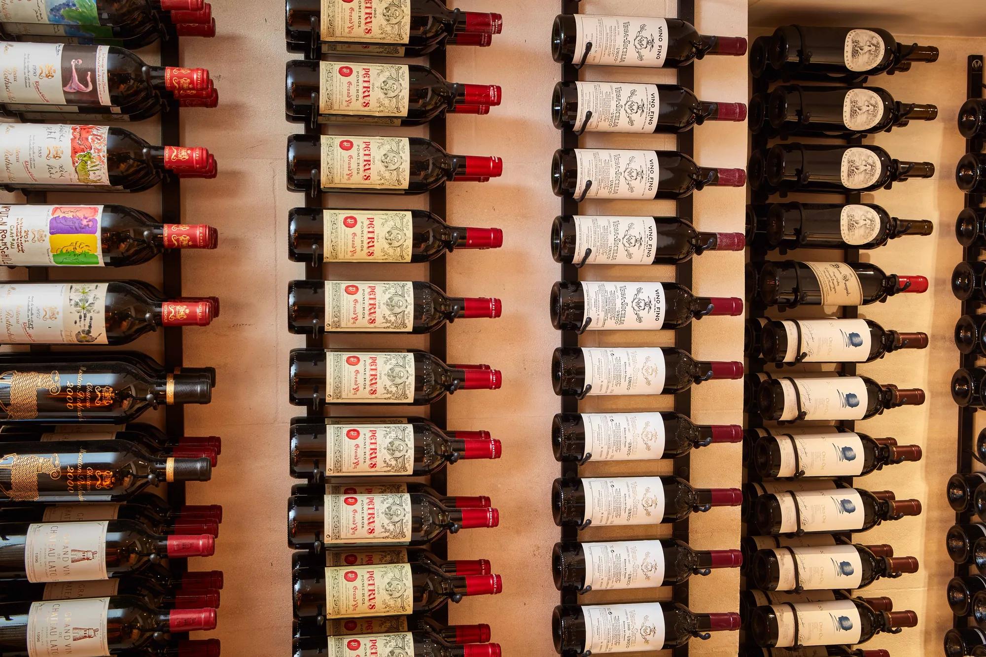 Rows of wine bottles displayed on wall racks, labels facing outward.