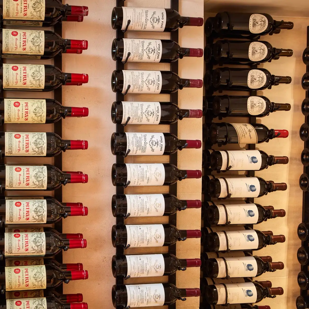 Rows of wine bottles displayed on wall racks, labels facing outward.