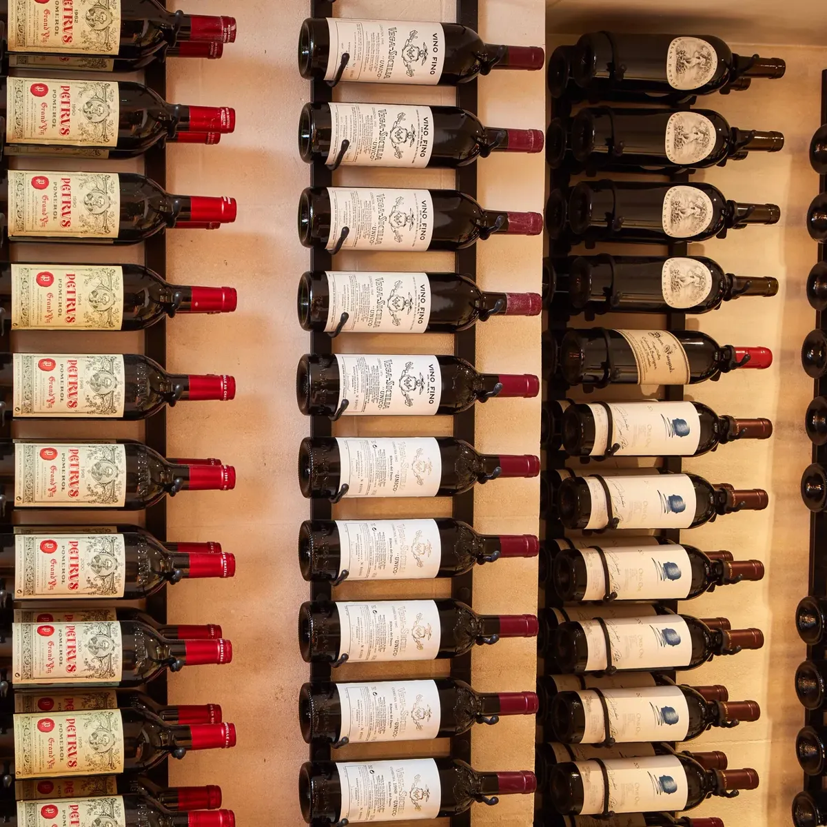 Rows of wine bottles displayed on wall racks, labels facing outward.