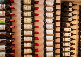Rows of wine bottles displayed on wall racks, labels facing outward.