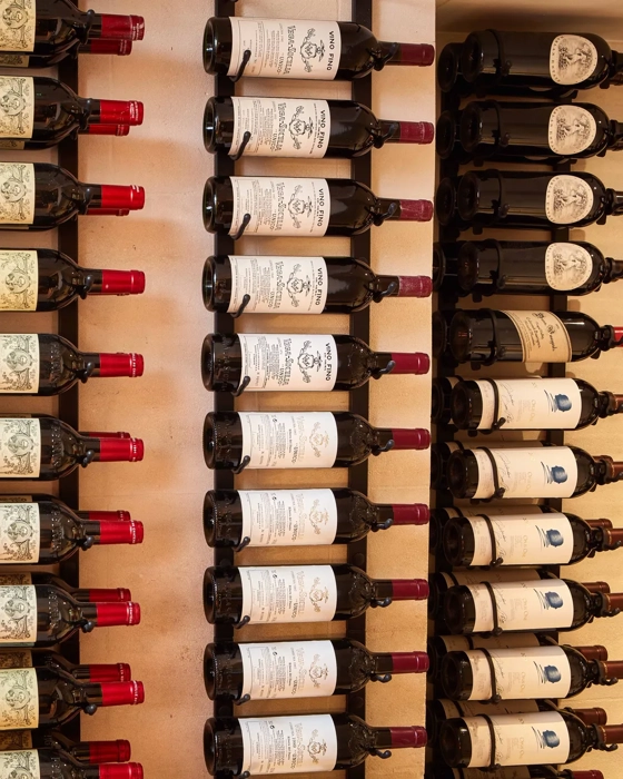 Rows of wine bottles displayed on wall racks, labels facing outward.