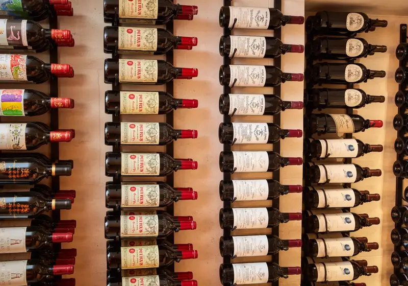 Rows of wine bottles displayed on wall racks, labels facing outward.