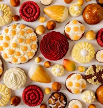 Assorted pastries with mango, pear, citrus and chocolate, decorated with floral cream and spiral patterns in vibrant spring colours