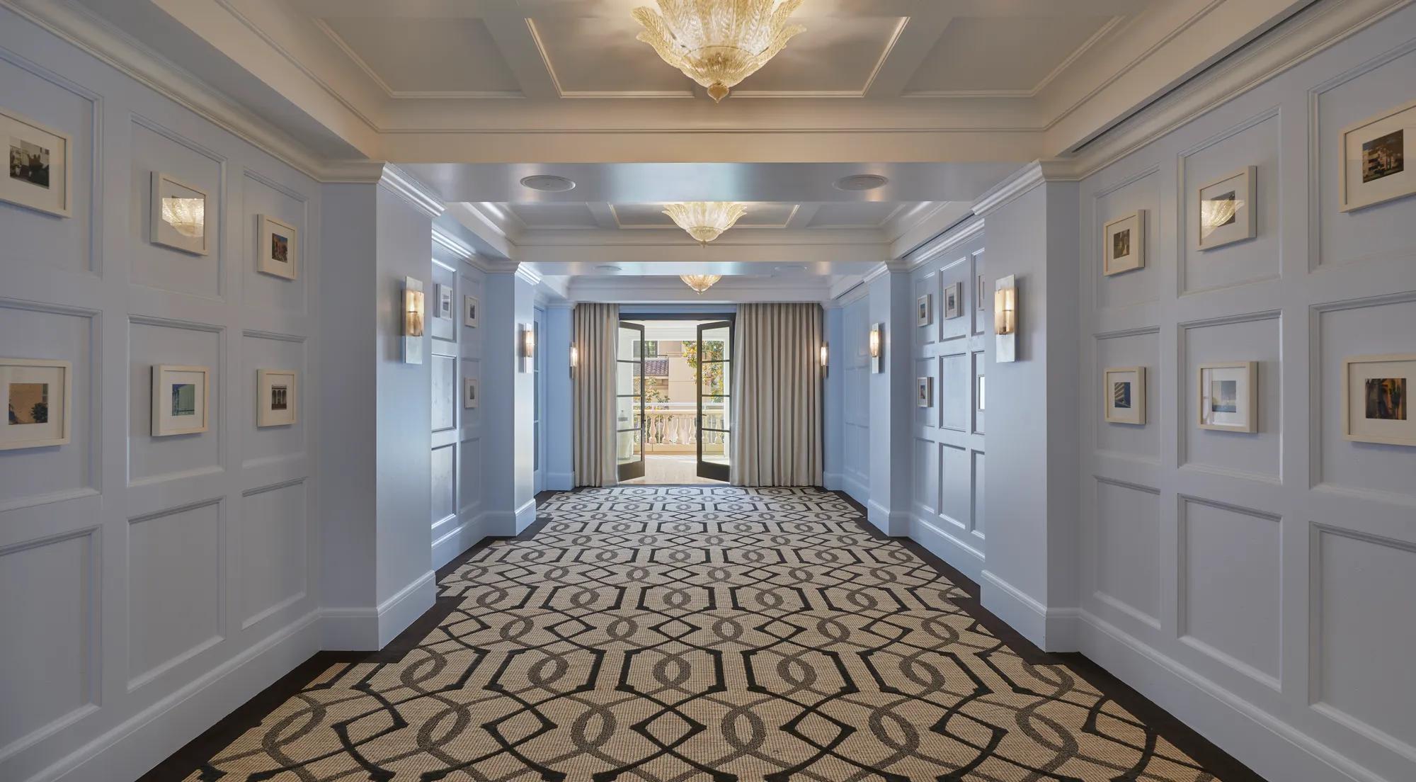 Canon Room foyer with blue paneled walls, framed art, and terrace doors.